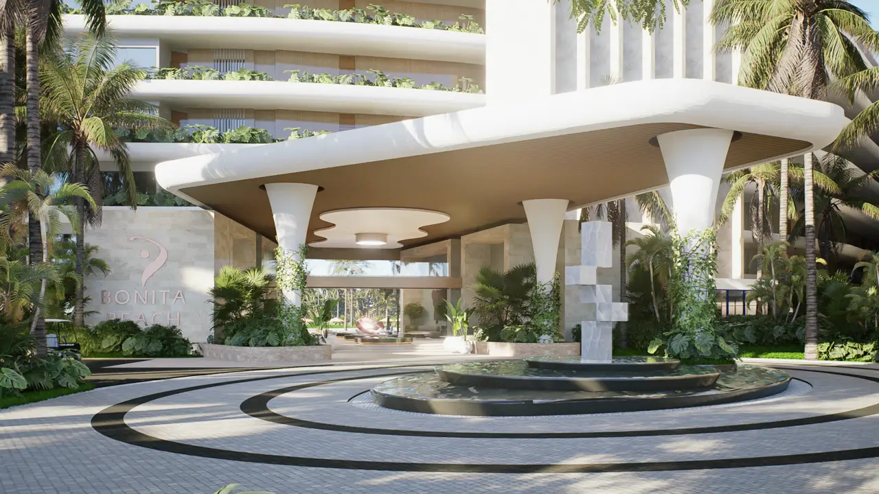 La cour d'entrée de Bonita Beach : l'auvent de bois sculpté, la fontaine et la sculpture au bord de l'allée.