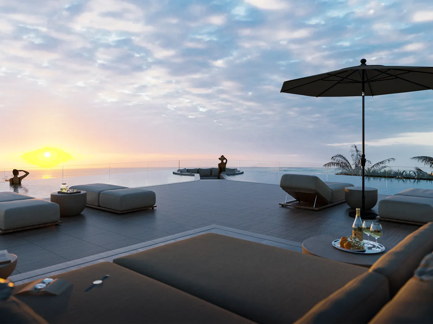 Le toit-terrasse de Bonita Beach au coucher du soleil : des lits de repos et un parasol face à la mer des Caraïbes.