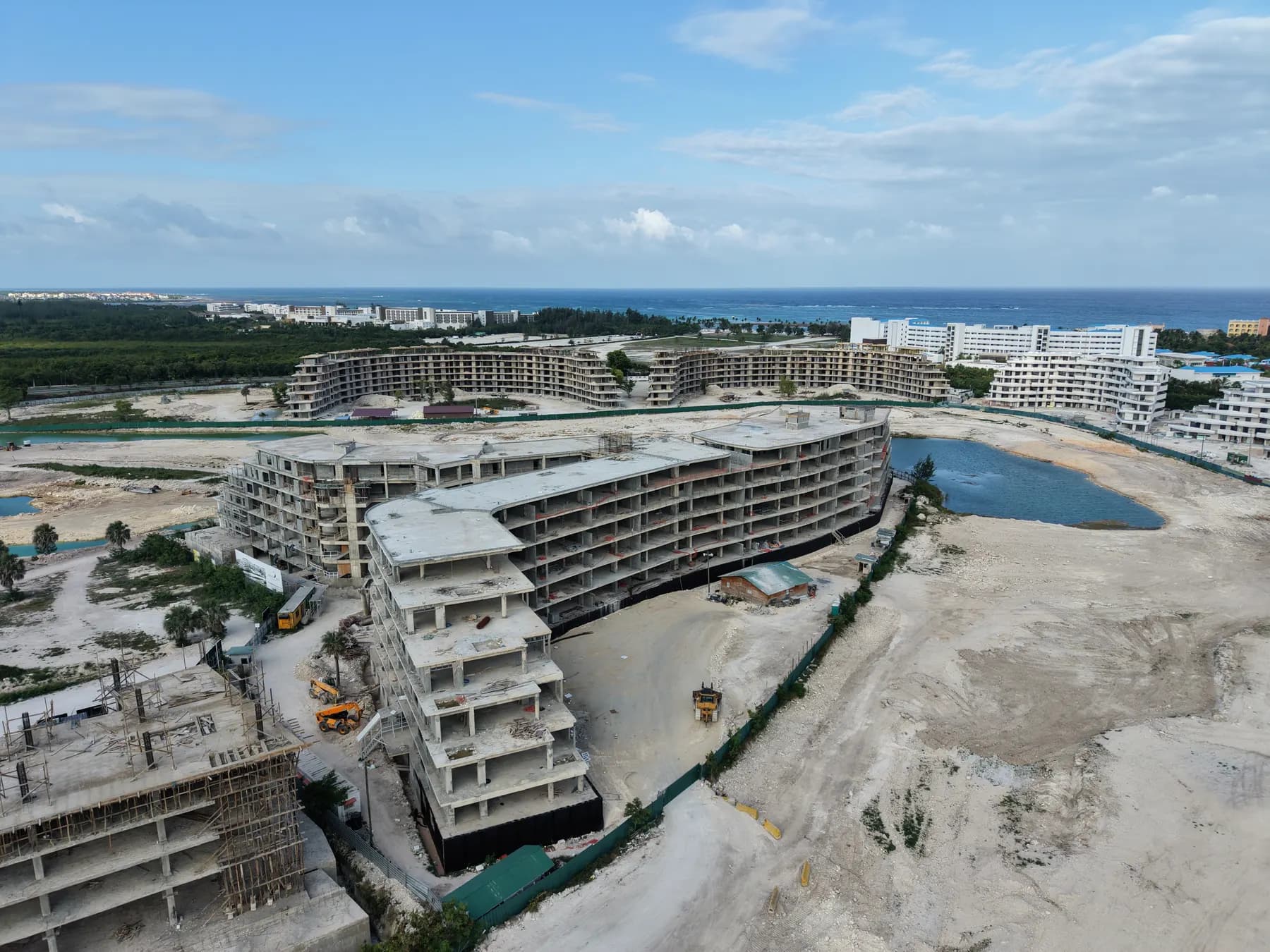 Photographie réelle par drone du chantier de Bonita Golf en juin 2026 : le bâtiment s'élève au bord de la lagune.