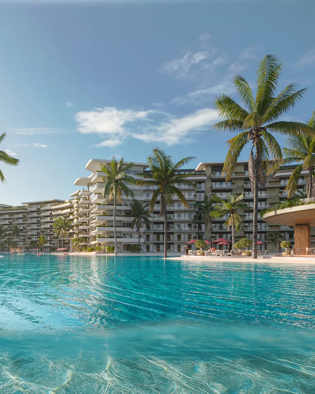La lagune de Bonita Beach au ras de l'eau : l'eau turquoise au premier plan, les résidences courbes et le bar de plage sur la rive opposée.