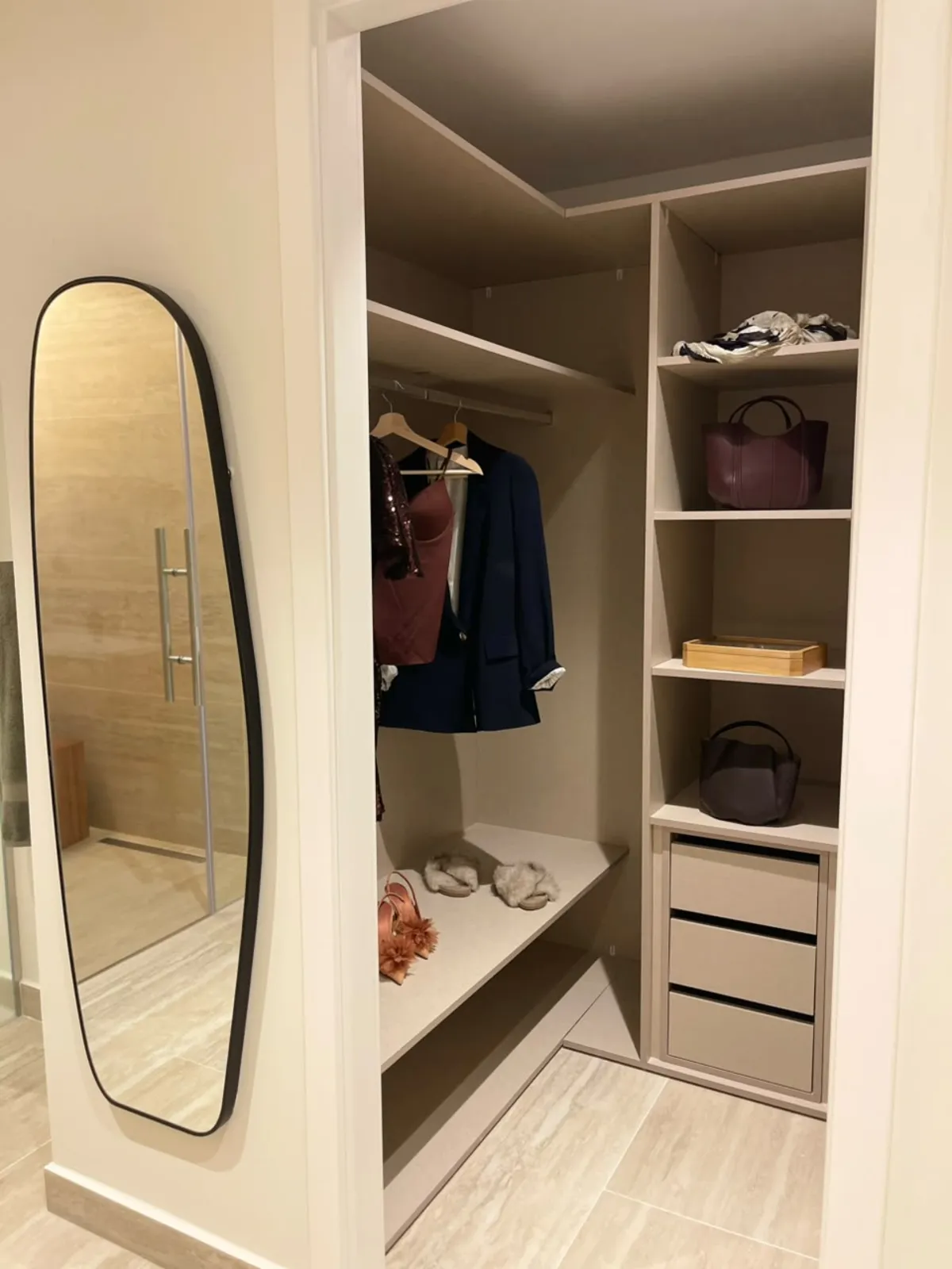 Photographie du dressing de la résidence témoin : étagères ouvertes, penderie, miroir en pied.